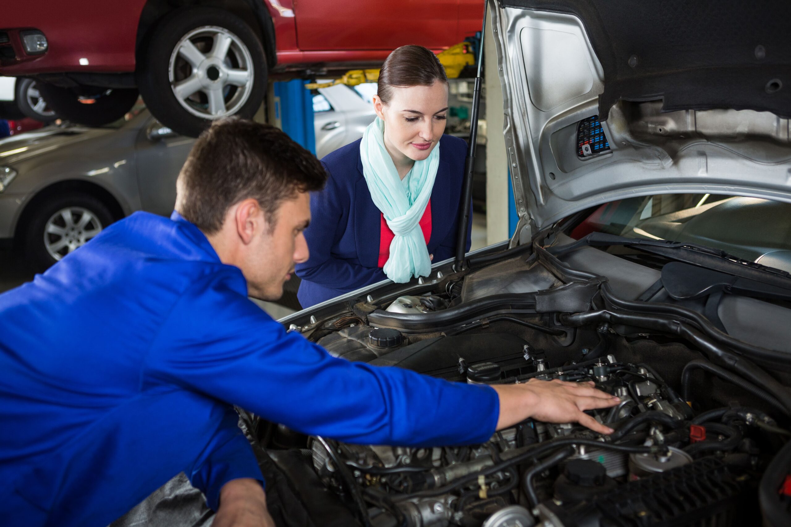 mechanic-showing-customer-problem-with-car-min